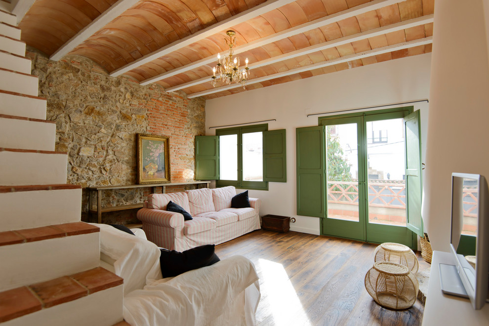 Exempel på ett mellanstort medelhavsstil separat vardagsrum, med ett finrum, vita väggar, mellanmörkt trägolv, en fristående TV och brunt golv