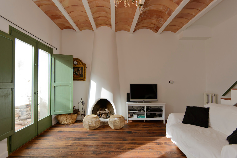 Inspiration pour un salon méditerranéen de taille moyenne et fermé avec une salle de réception, un mur blanc, un sol en bois brun, aucune cheminée, un téléviseur indépendant et un sol marron.