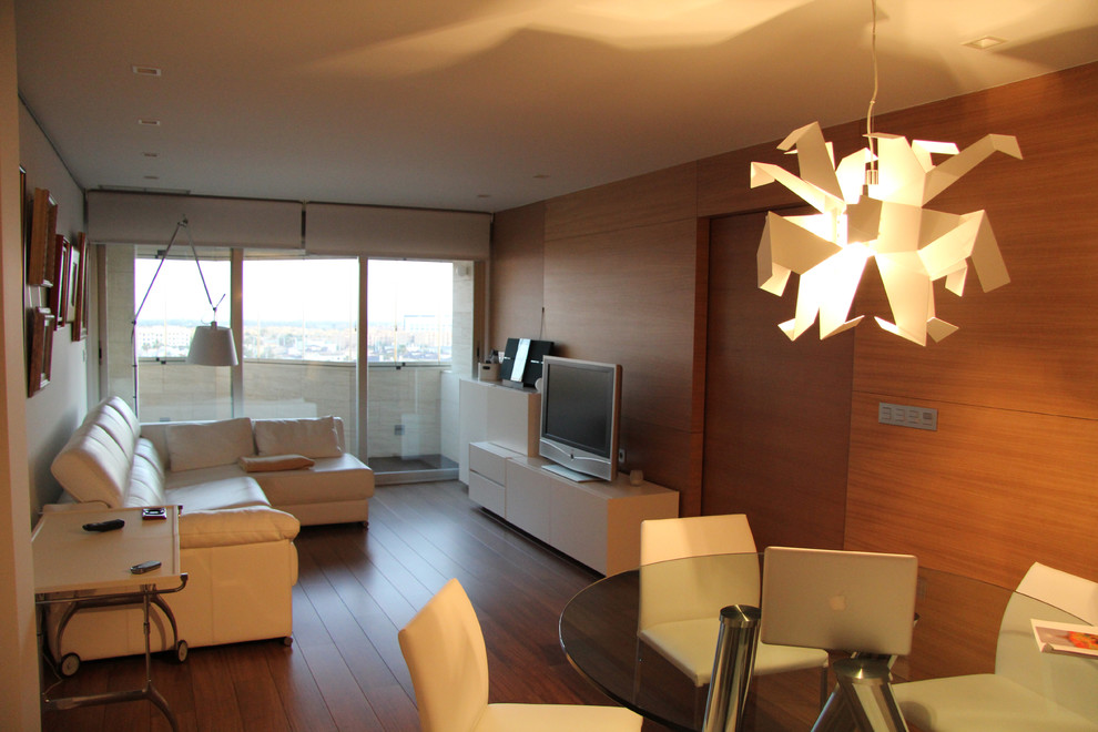 Modelo de salón para visitas abierto contemporáneo de tamaño medio sin chimenea con paredes marrones, suelo de madera en tonos medios y pared multimedia