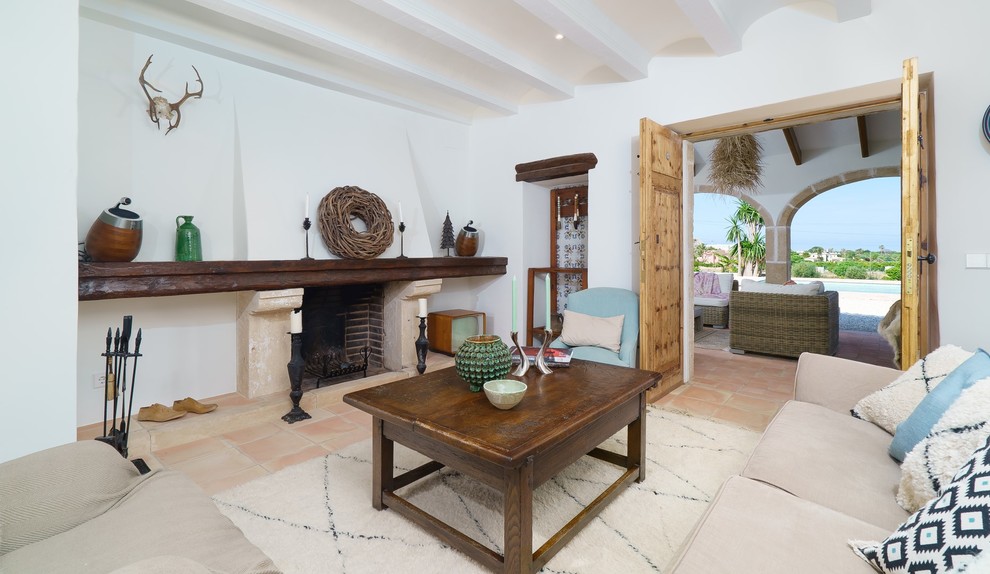 Mediterranean formal enclosed living room in Alicante-Costa Blanca with white walls, a standard fireplace, a stone fireplace surround, terracotta flooring, no tv and beige floors.