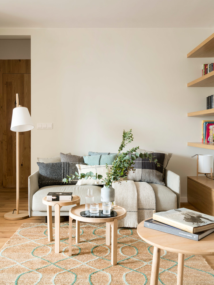 Imagen de biblioteca en casa abierta nórdica de tamaño medio con suelo de madera clara y paredes blancas