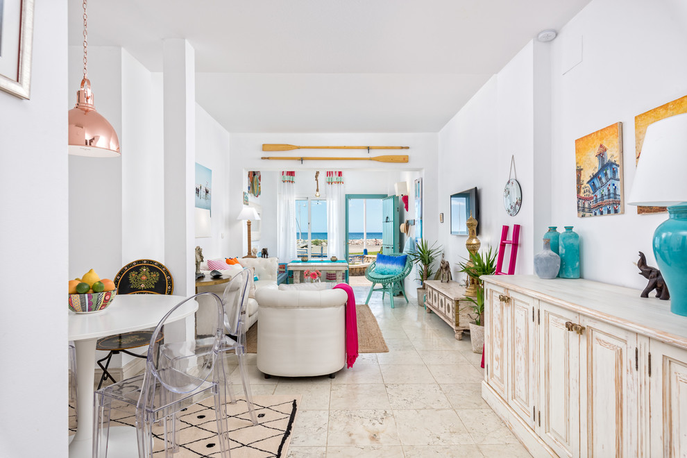 Imagen de salón para visitas abierto tropical de tamaño medio sin chimenea con paredes blancas y televisor colgado en la pared