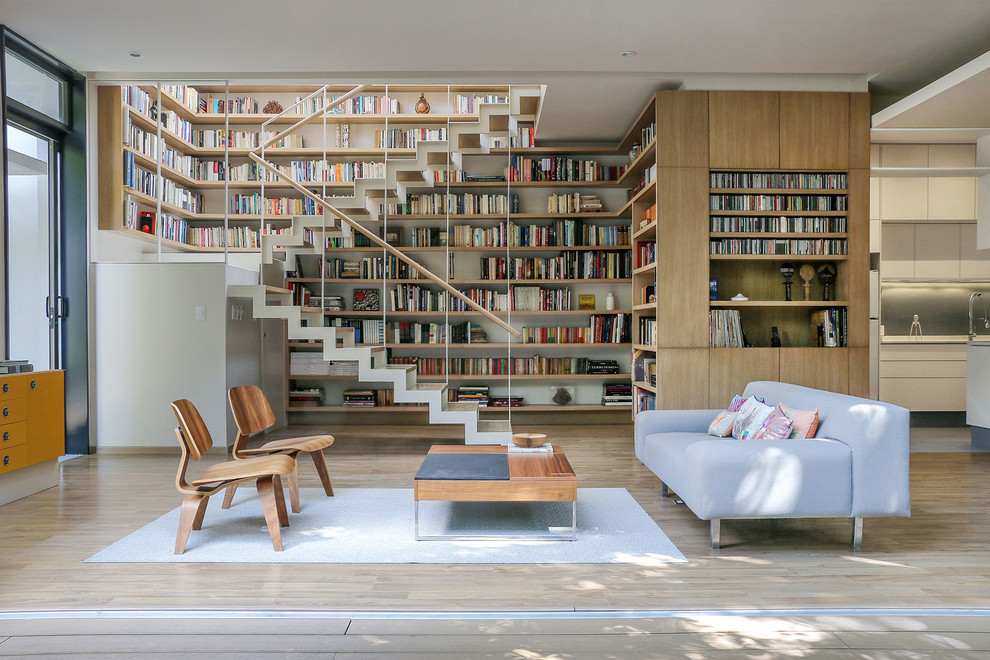 Foto på ett minimalistiskt allrum med öppen planlösning, med ett bibliotek