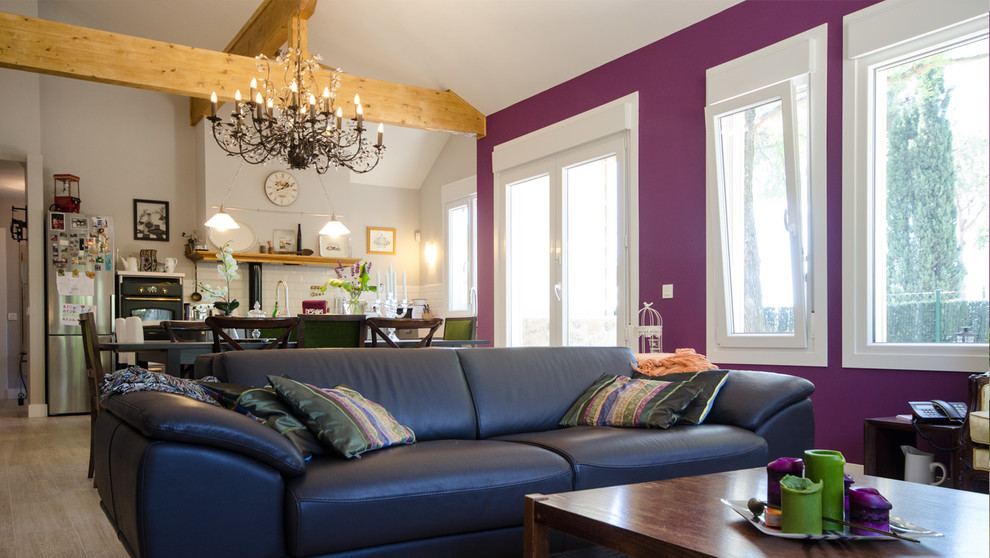 Imagen de salón abierto bohemio de tamaño medio con paredes púrpuras, suelo de baldosas de cerámica y televisor independiente
