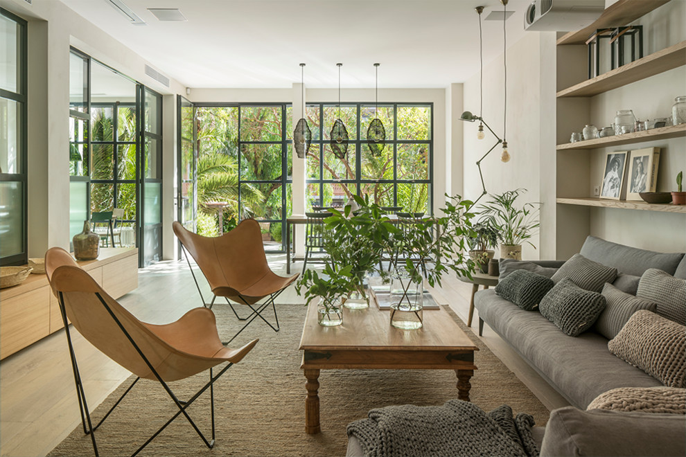Ispirazione per un grande soggiorno aperto con pareti beige, pavimento in legno massello medio, TV autoportante e pavimento marrone