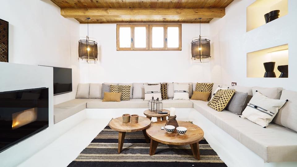 Mittelgroßes, Offenes Mediterranes Wohnzimmer mit weißer Wandfarbe, Betonboden, Kamin, Kaminumrandung aus Beton, TV-Wand und weißem Boden in Valencia