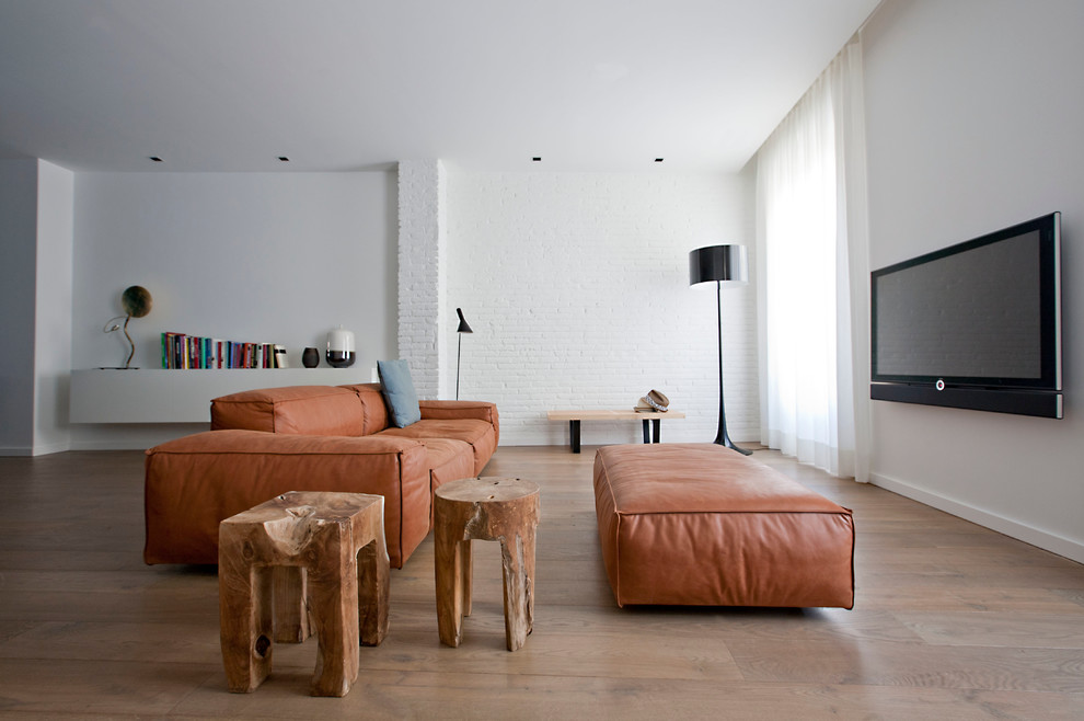 Großes, Repräsentatives, Offenes Modernes Wohnzimmer ohne Kamin mit weißer Wandfarbe, braunem Holzboden und TV-Wand in Valencia