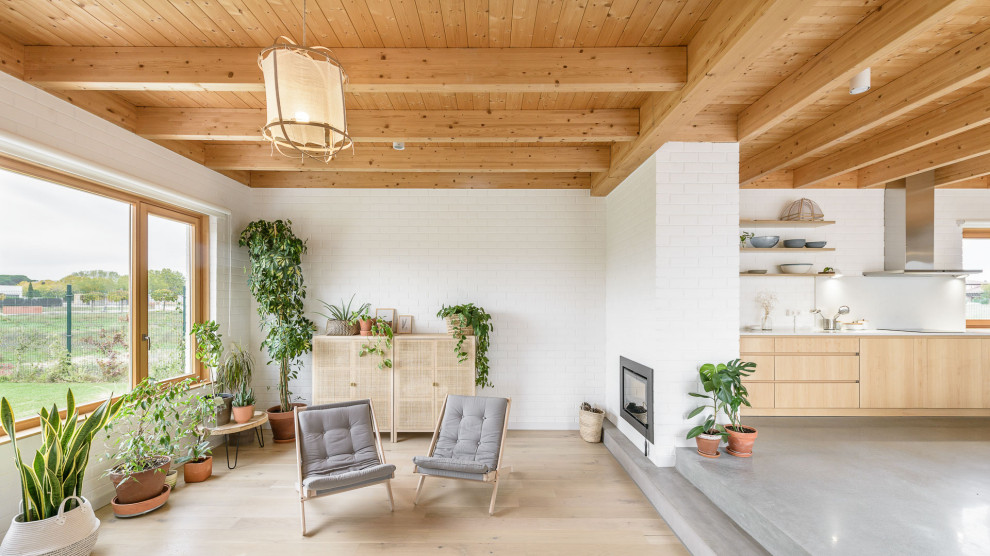 Inspiration for a mid-sized contemporary formal and open concept light wood floor, beige floor, wood ceiling and brick wall living room remodel in Other with white walls, a standard fireplace, a brick fireplace and no tv