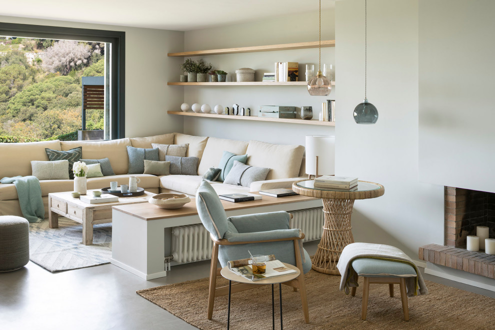 This is an example of a large mediterranean open plan living room in Barcelona with grey walls, concrete flooring, a wood burning stove, a brick fireplace surround and grey floors.