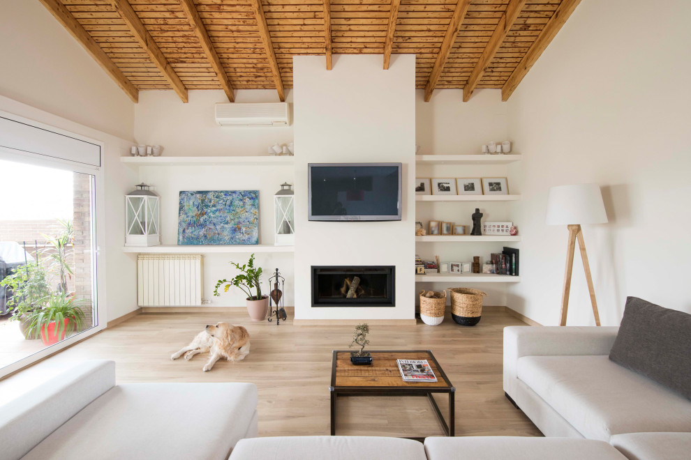 Свежая идея для дизайна: гостиная комната в средиземноморском стиле с белыми стенами, паркетным полом среднего тона, горизонтальным камином, телевизором на стене, коричневым полом и деревянным потолком - отличное фото интерьера