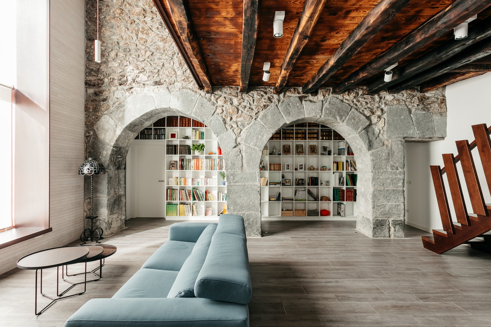 Idéer för ett rustikt allrum med öppen planlösning, med ett bibliotek, vita väggar och brunt golv