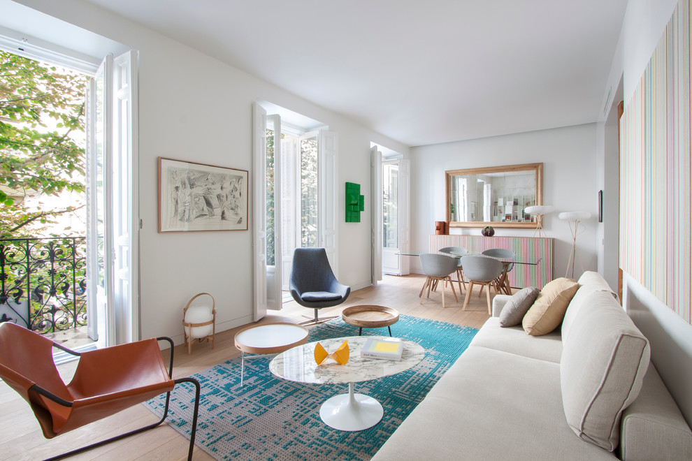Offenes, Mittelgroßes, Repräsentatives, Fernseherloses Skandinavisches Wohnzimmer ohne Kamin mit hellem Holzboden und weißer Wandfarbe in Madrid