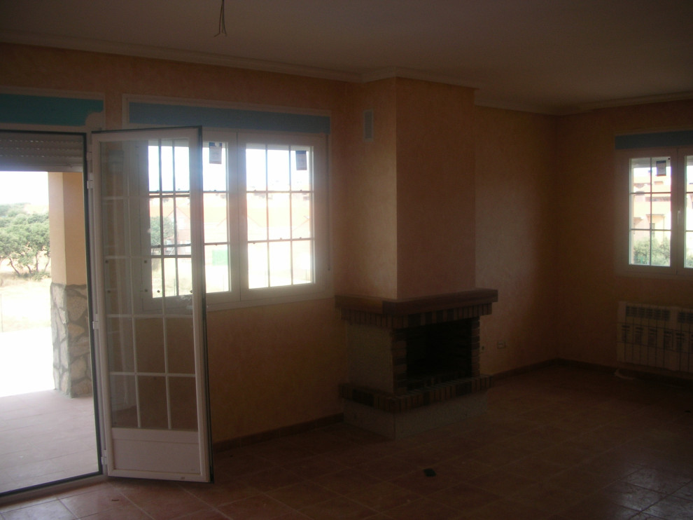 Inredning av ett lantligt mycket stort separat vardagsrum, med beige väggar, klinkergolv i keramik, en standard öppen spis, en spiselkrans i tegelsten och brunt golv