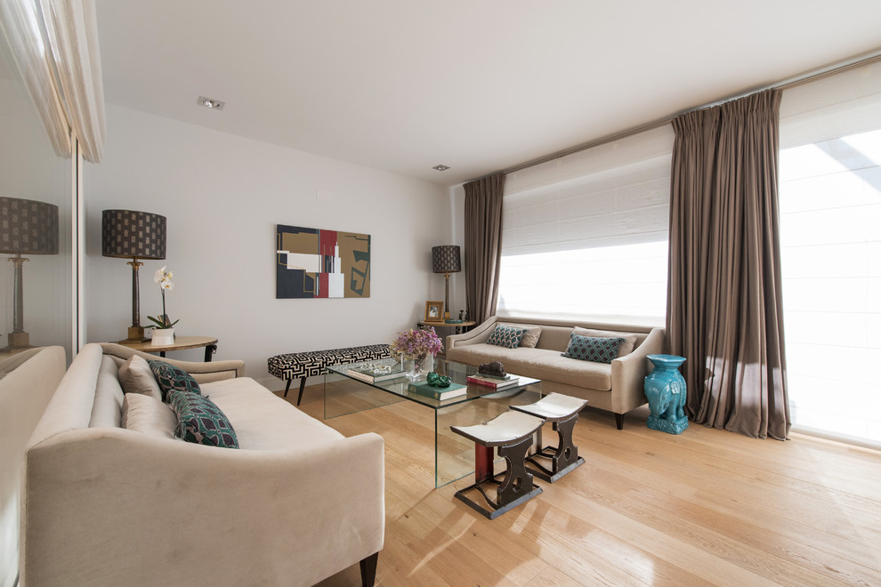 Modernes Wohnzimmer mit weißer Wandfarbe, hellem Holzboden und beigem Boden in Madrid