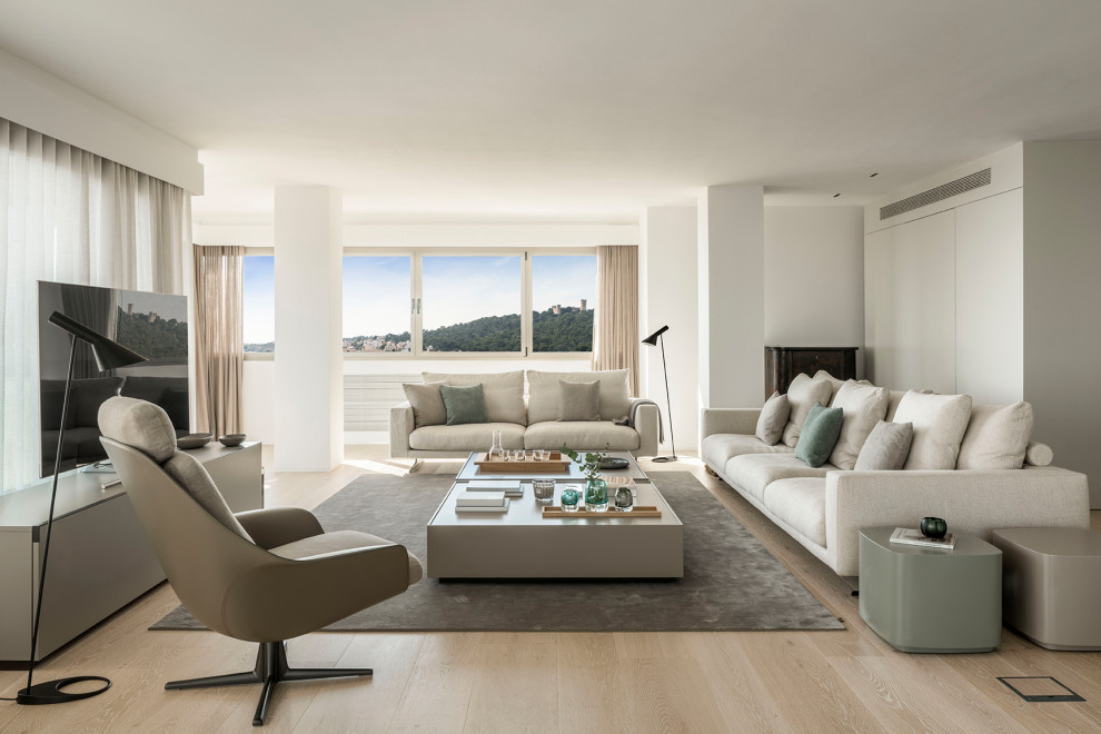 Immagine di un soggiorno minimal aperto con pareti bianche, parquet chiaro, TV autoportante e pavimento beige