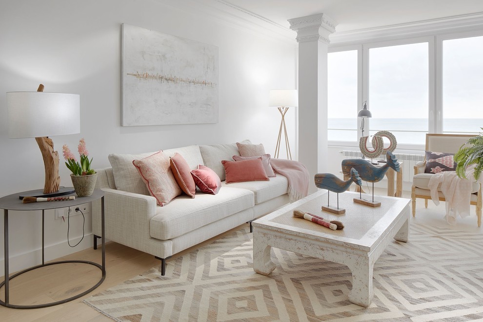 Ispirazione per un soggiorno stile marinaro di medie dimensioni con pareti bianche, parquet chiaro e pavimento beige