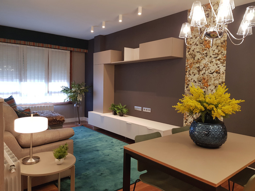 Imagen de salón abierto contemporáneo con paredes grises y suelo de madera en tonos medios