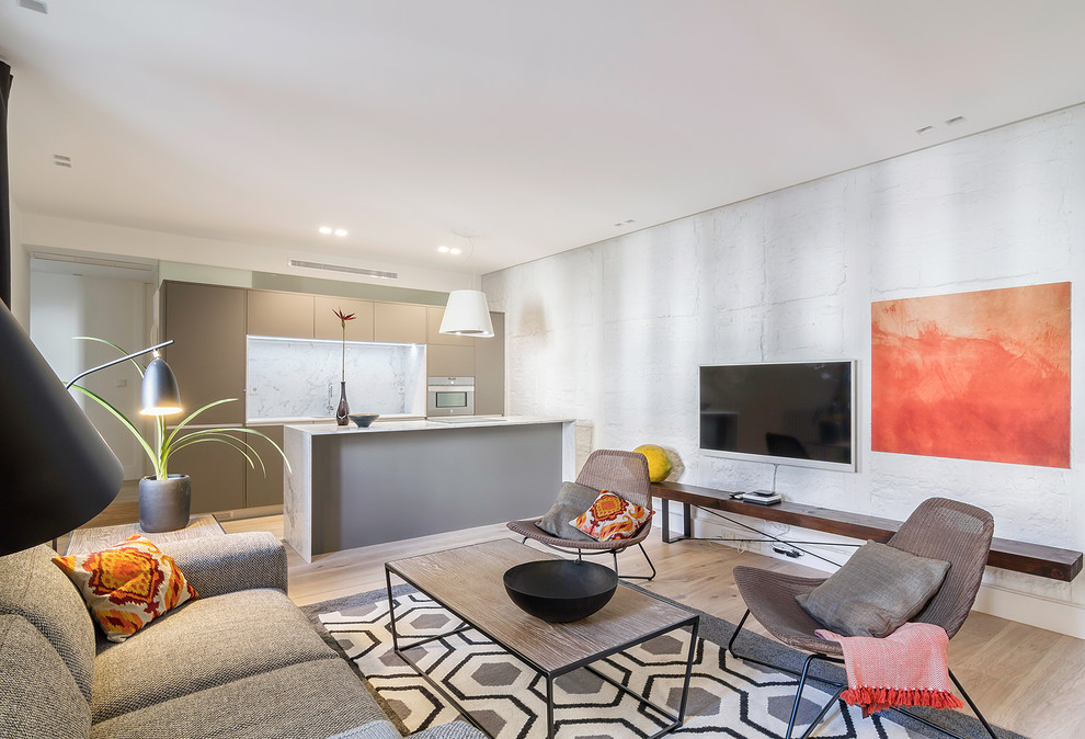 Idee per un soggiorno minimal aperto con pareti bianche, TV a parete, parquet chiaro e pavimento beige