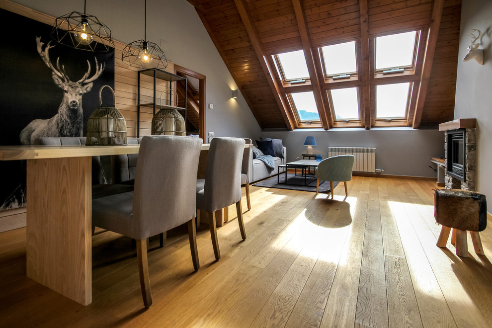 Landhausstil Wohnzimmer mit hellem Holzboden, Kamin und Kaminumrandung aus Stein in Sonstige