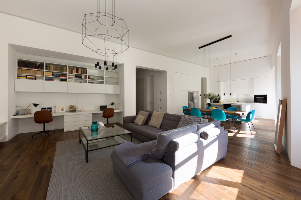Diseño de salón abierto contemporáneo con paredes blancas, suelo de madera en tonos medios y suelo marrón