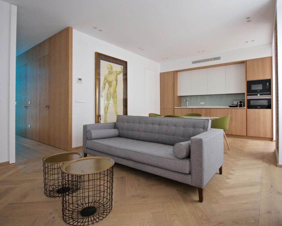 Ejemplo de salón para visitas abierto actual con paredes blancas, suelo de madera clara y suelo beige