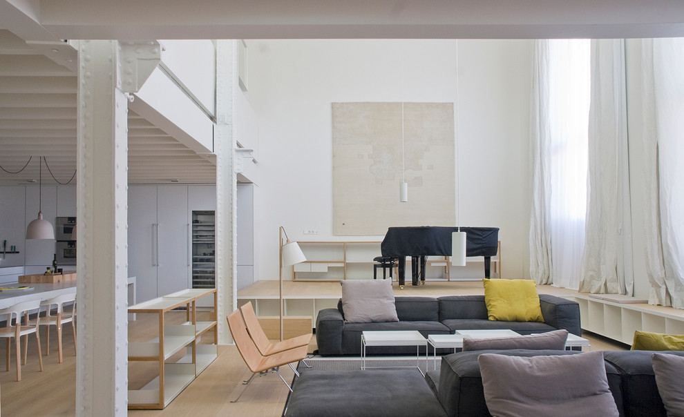 This is an example of a large contemporary formal living room in Barcelona with white walls, light hardwood flooring, no fireplace and no tv.