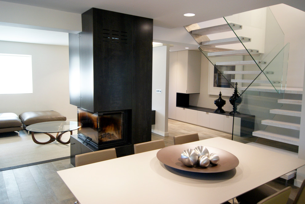 Cette image montre un grand salon minimaliste ouvert avec un sol en carrelage de porcelaine, une cheminée ribbon, un manteau de cheminée en métal et un téléviseur fixé au mur.