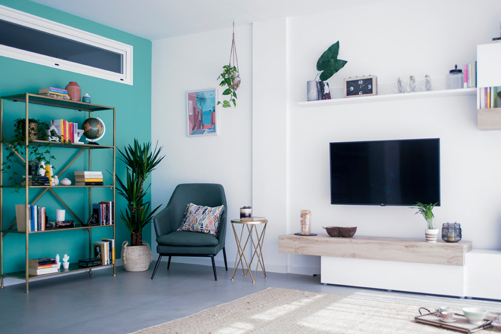 Стильный дизайн: открытая гостиная комната среднего размера в стиле фьюжн с зелеными стенами, бетонным полом, телевизором на стене и серым полом - последний тренд