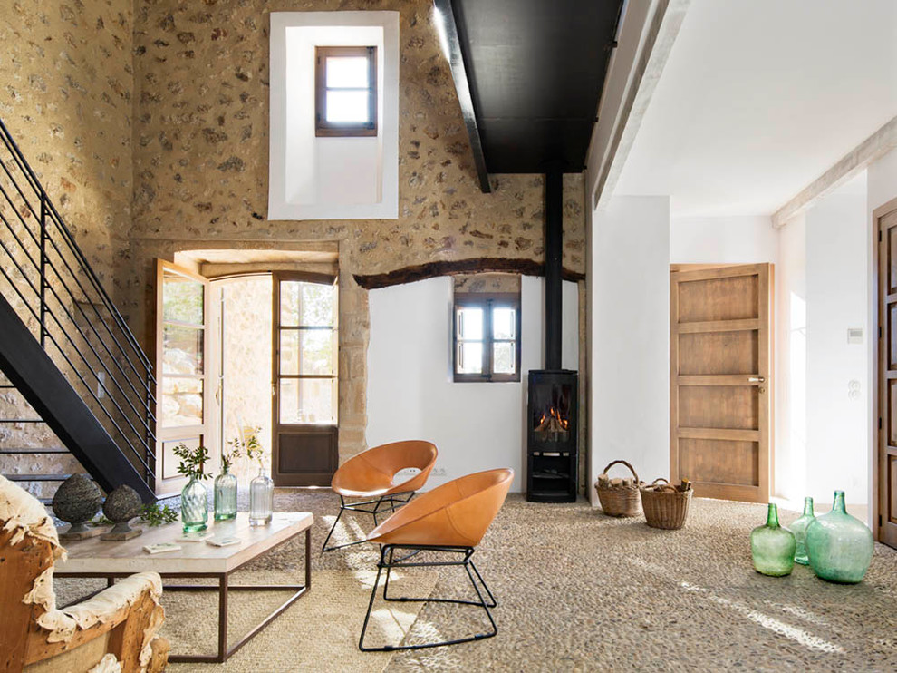 Idées déco pour un salon méditerranéen ouvert et de taille moyenne avec un mur blanc, un poêle à bois, une salle de réception, aucun téléviseur, un mur en pierre et un escalier.