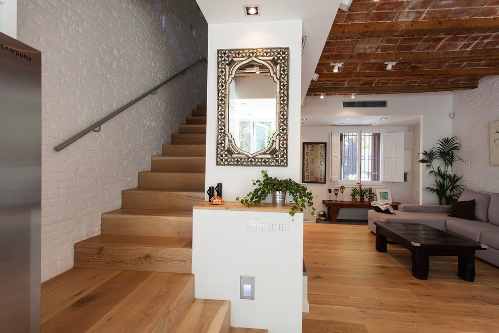 Foto de salón abierto urbano de tamaño medio con paredes blancas, suelo de madera en tonos medios y suelo marrón