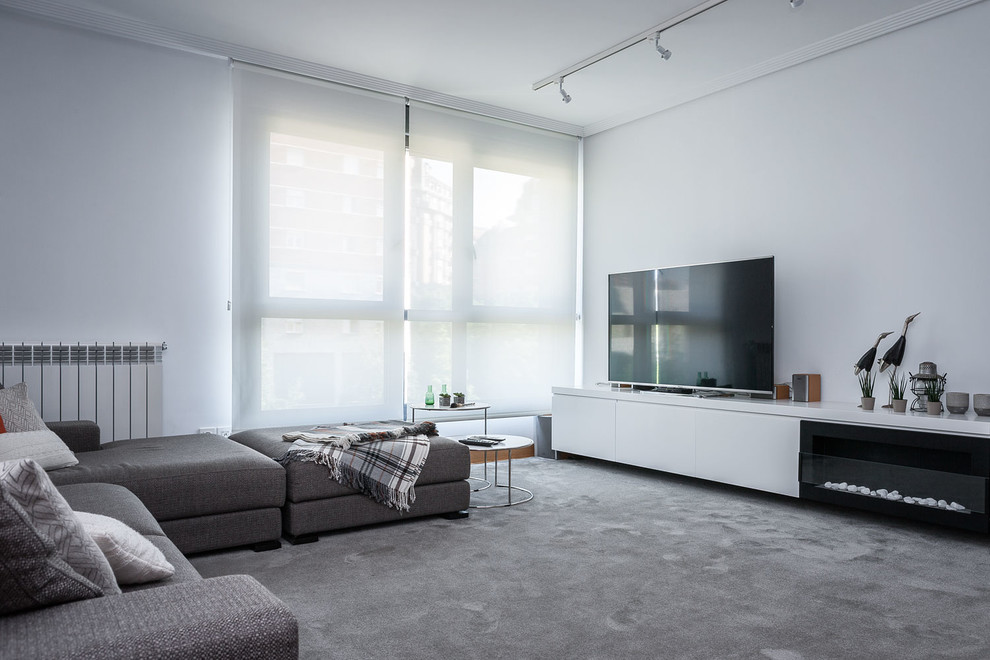 Imagen de salón abierto moderno de tamaño medio con paredes blancas, chimenea lineal, marco de chimenea de metal, televisor independiente, moqueta y suelo gris