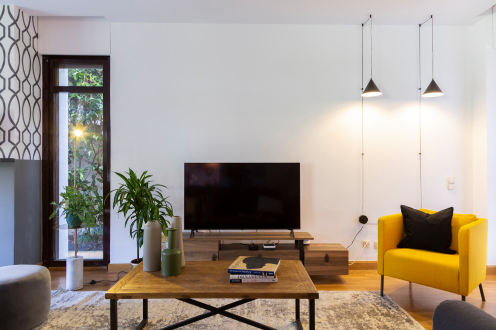 Foto på ett mellanstort eklektiskt separat vardagsrum, med ett musikrum, vita väggar, mellanmörkt trägolv, en standard öppen spis, en spiselkrans i gips och en fristående TV