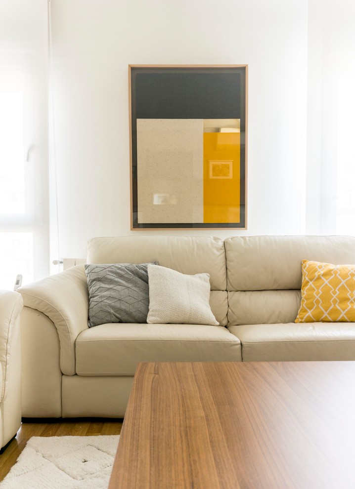Modelo de salón cerrado actual de tamaño medio con paredes grises, suelo de madera en tonos medios, televisor independiente y suelo marrón