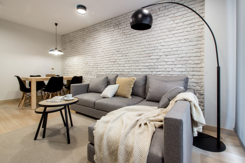 Источник вдохновения для домашнего уюта: маленькая изолированная гостиная комната в скандинавском стиле с серыми стенами, светлым паркетным полом, телевизором на стене и кирпичными стенами для на участке и в саду