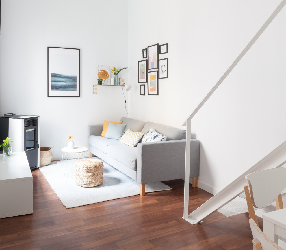 Idéer för ett mellanstort minimalistiskt loftrum, med vita väggar, laminatgolv, en öppen vedspis och brunt golv