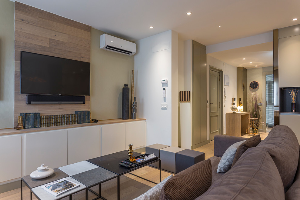 Источник вдохновения для домашнего уюта: открытая гостиная комната среднего размера в современном стиле с белыми стенами, полом из ламината и телевизором на стене