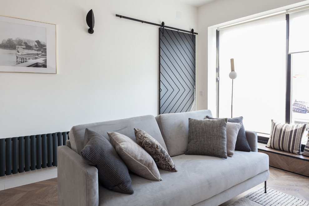 This is an example of a medium sized scandi open plan living room in Madrid with white walls, laminate floors, a ribbon fireplace, a wooden fireplace surround, a wall mounted tv and brown floors.