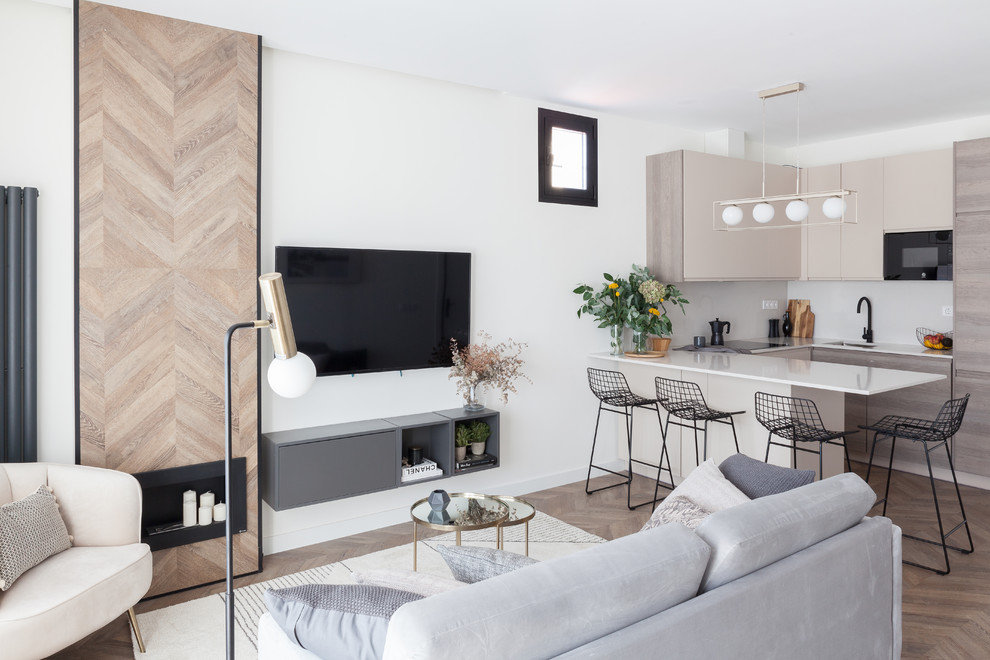 Photo of a medium sized scandi open plan living room in Madrid with white walls, laminate floors, a ribbon fireplace, a wooden fireplace surround, a wall mounted tv and brown floors.