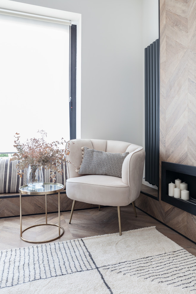 マドリードにあるお手頃価格の中くらいな北欧スタイルのおしゃれなLDK (白い壁、ラミネートの床、横長型暖炉、木材の暖炉まわり、壁掛け型テレビ、茶色い床) の写真