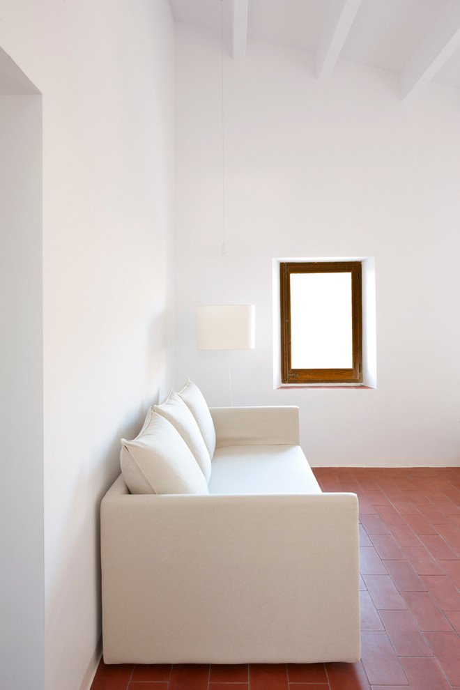 Diseño de salón abierto mediterráneo de tamaño medio sin chimenea y televisor con paredes blancas, suelo de baldosas de cerámica y suelo marrón