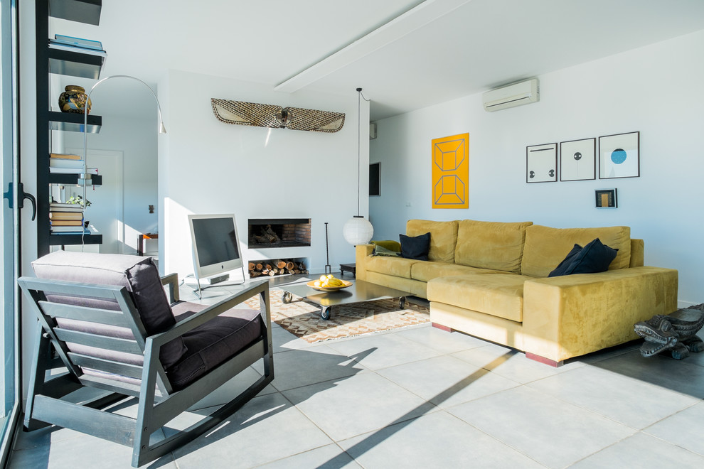 This is an example of a large contemporary formal open plan living room in Malaga with white walls, concrete flooring, a standard fireplace and a freestanding tv.