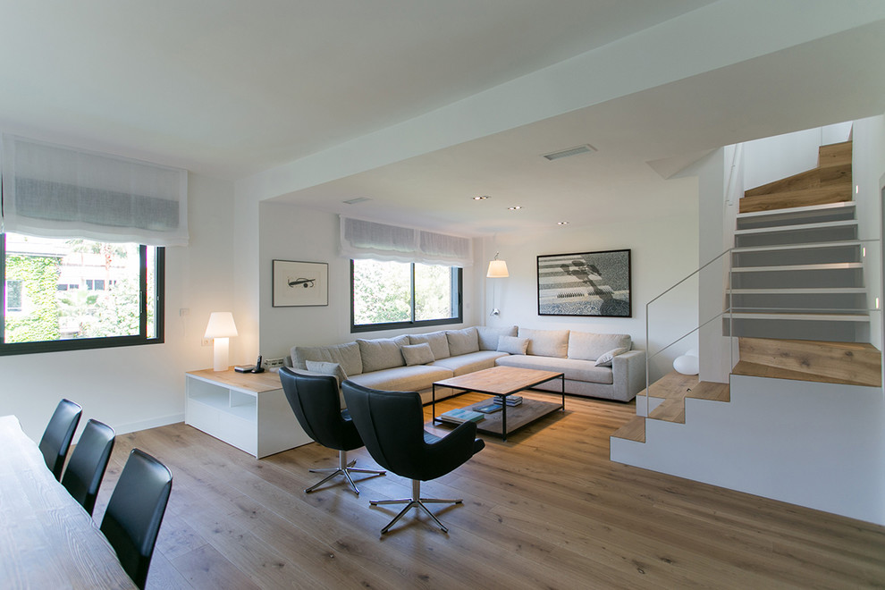 Foto de salón para visitas abierto nórdico grande sin chimenea y televisor con paredes blancas y suelo de madera en tonos medios