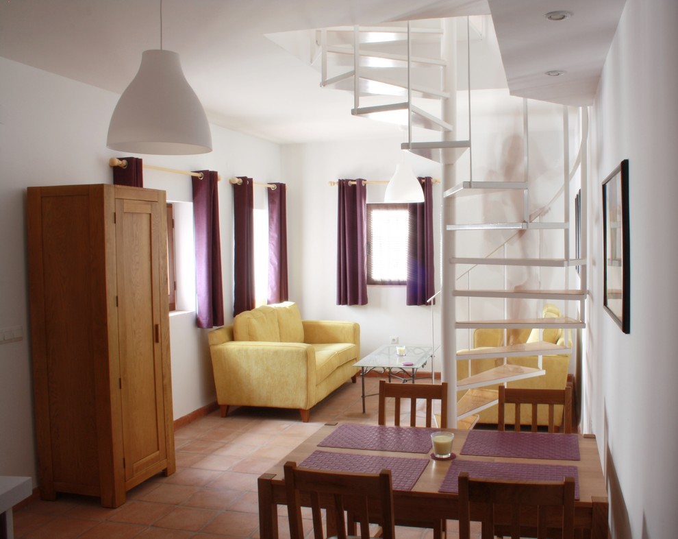 Ejemplo de salón abierto tradicional renovado pequeño sin chimenea con paredes blancas y suelo de baldosas de terracota