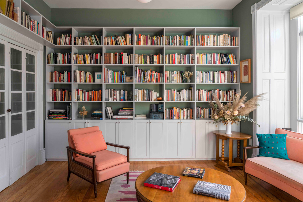 Источник вдохновения для домашнего уюта: большая изолированная гостиная комната в стиле неоклассика (современная классика) с с книжными шкафами и полками, зелеными стенами, паркетным полом среднего тона и многоуровневым потолком
