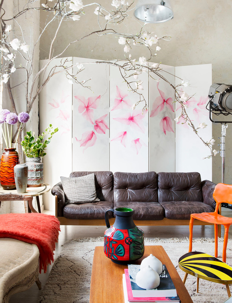 This is an example of an eclectic living room in Madrid with beige walls and light hardwood flooring.