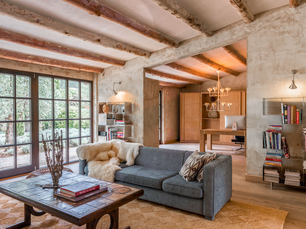 Ejemplo de biblioteca en casa mediterránea con paredes grises y suelo de madera clara