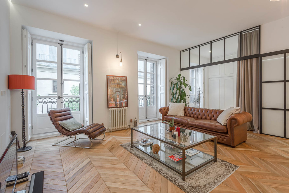 Großes, Abgetrenntes Klassisches Wohnzimmer mit weißer Wandfarbe, braunem Holzboden, freistehendem TV und braunem Boden in Madrid