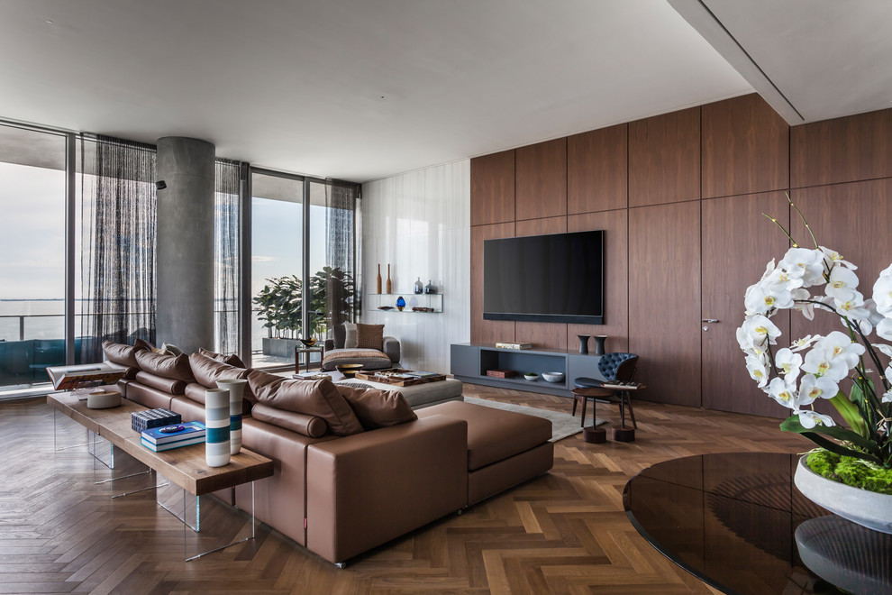 Modern inredning av ett vardagsrum, med bruna väggar, mellanmörkt trägolv, en väggmonterad TV och brunt golv