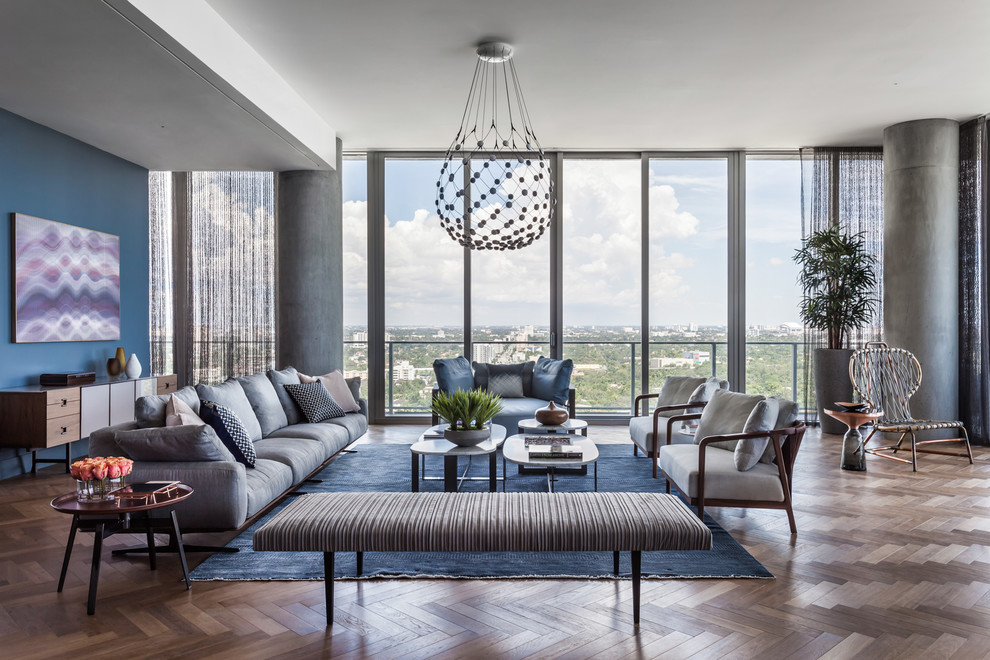Idee per un soggiorno contemporaneo con pareti blu, pavimento in legno massello medio e pavimento marrone