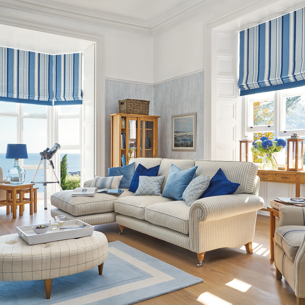 Mittelgroßes, Fernseherloses, Offenes, Repräsentatives Maritimes Wohnzimmer ohne Kamin mit braunem Holzboden und blauer Wandfarbe in Sonstige